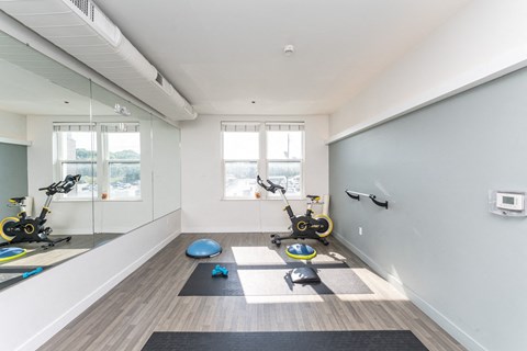 a workout room with yoga equipment and mirrors in a home gym